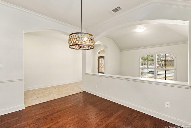 empty room featuring wood finished floors, baseboards, crown molding, and an inviting chandelier