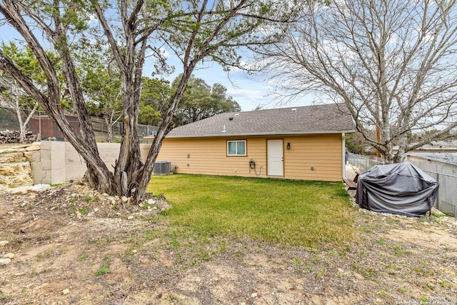 back of house featuring a lawn and central air condition unit