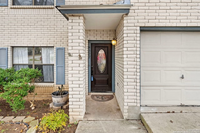 entrance to property featuring brick siding and an attached garage