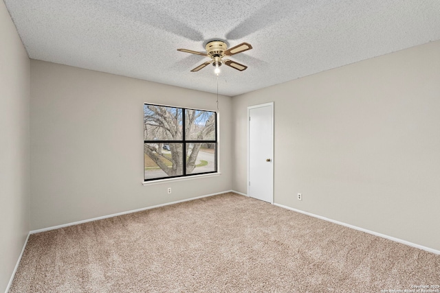 unfurnished room with carpet flooring, baseboards, a ceiling fan, and a textured ceiling