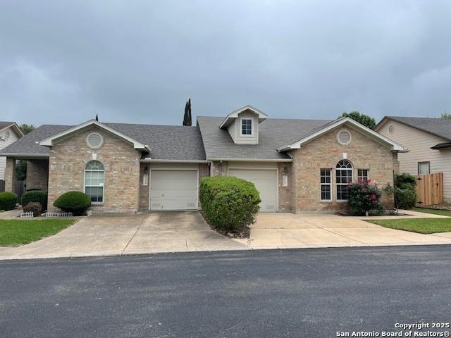 view of front of house featuring brick siding, driveway, and a garage