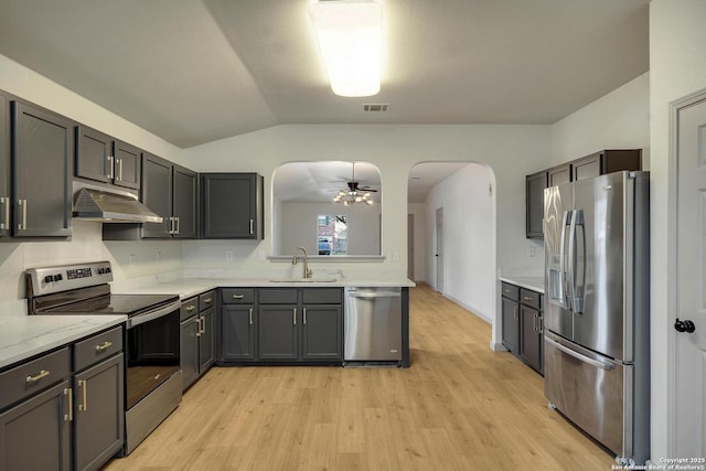 kitchen featuring a sink, under cabinet range hood, visible vents, appliances with stainless steel finishes, and arched walkways