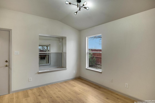 unfurnished room featuring light wood-style flooring, baseboards, and vaulted ceiling