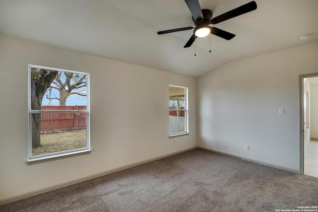 carpeted empty room with baseboards, lofted ceiling, a ceiling fan, and a healthy amount of sunlight