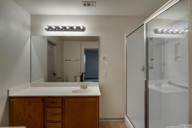 bathroom with a stall shower, visible vents, toilet, and vanity