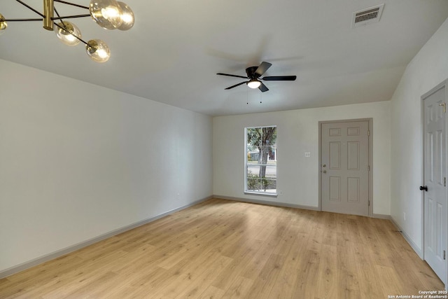 spare room with light wood-style flooring, baseboards, a ceiling fan, and visible vents