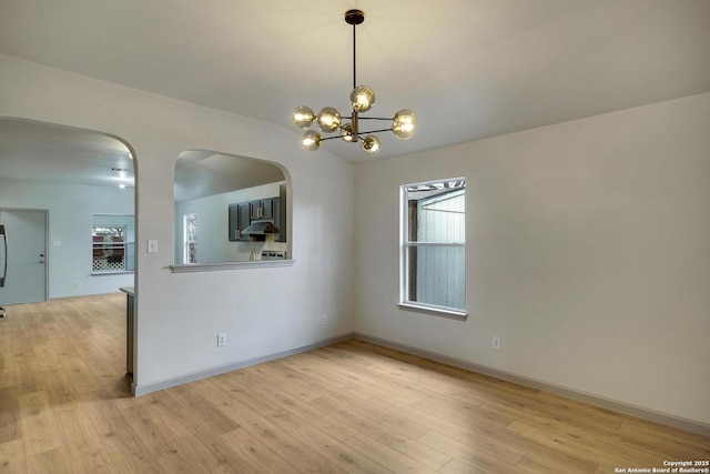 interior space featuring baseboards, an inviting chandelier, and light wood-style floors