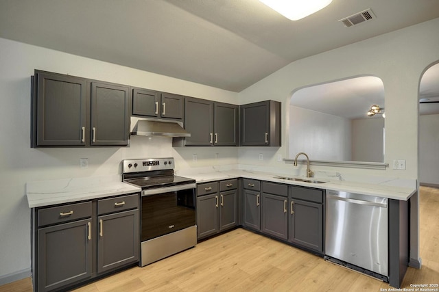 kitchen with visible vents, a sink, under cabinet range hood, lofted ceiling, and stainless steel appliances