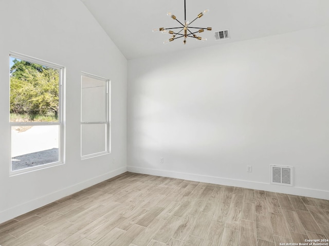 spare room featuring visible vents, baseboards, a notable chandelier, and light wood-type flooring