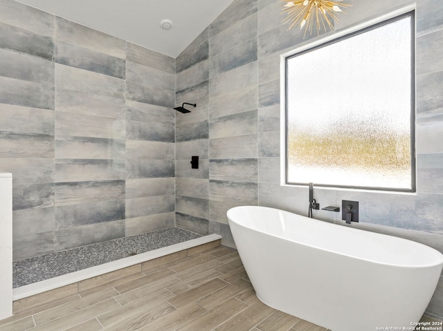 full bathroom with tile walls, tiled shower, a soaking tub, vaulted ceiling, and wood finish floors