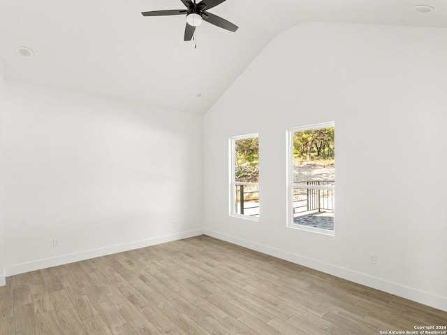 spare room with a ceiling fan, baseboards, light wood-style floors, and high vaulted ceiling