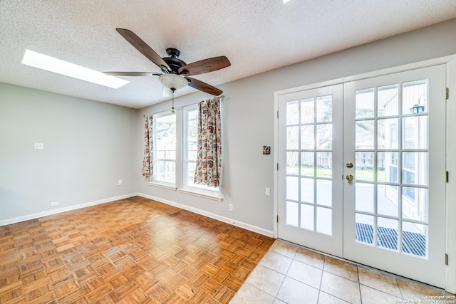 doorway featuring french doors, a skylight, baseboards, a textured ceiling, and ceiling fan