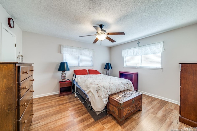 bedroom with light wood-style flooring, baseboards, ceiling fan, and multiple windows