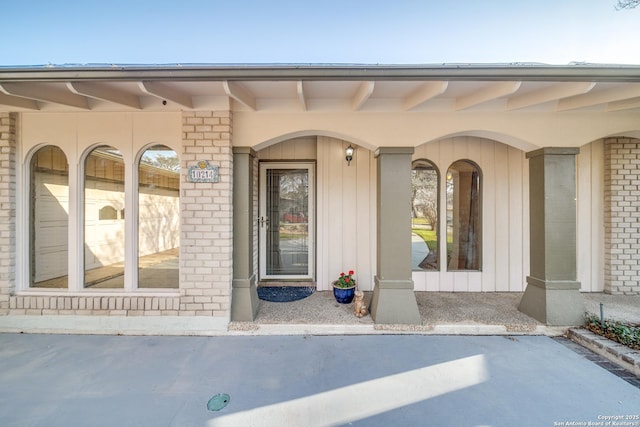 doorway to property featuring brick siding