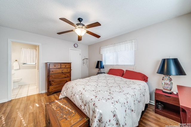 bedroom with baseboards, a textured ceiling, wood finished floors, a ceiling fan, and connected bathroom