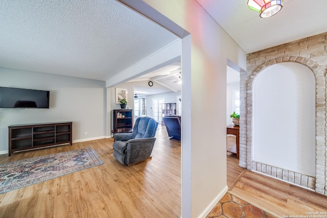 interior space with baseboards, a textured ceiling, and wood finished floors