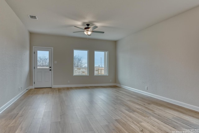 interior space featuring baseboards, light wood-style flooring, visible vents, and a ceiling fan