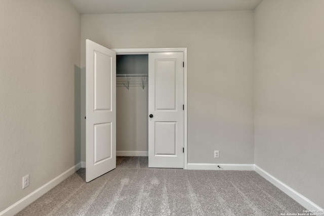 unfurnished bedroom featuring a closet, baseboards, and carpet flooring