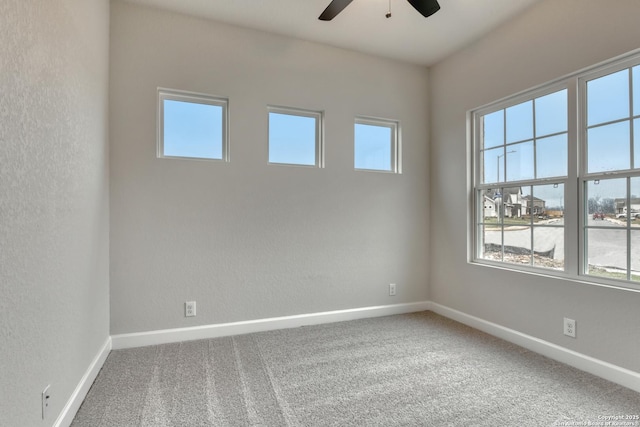 spare room with a ceiling fan, baseboards, and carpet flooring