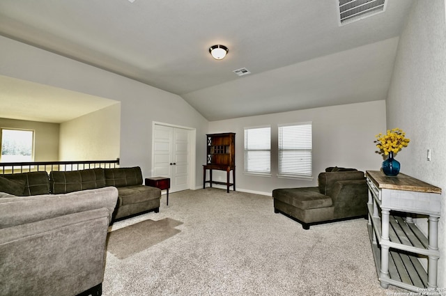 carpeted living area with baseboards, visible vents, and vaulted ceiling