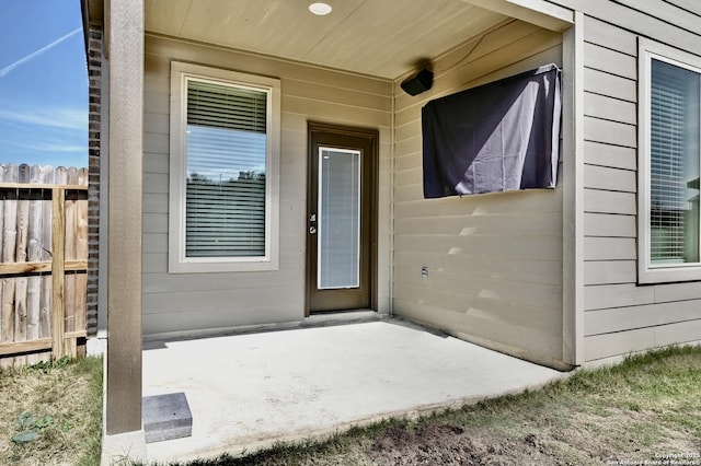 entrance to property with a patio and fence