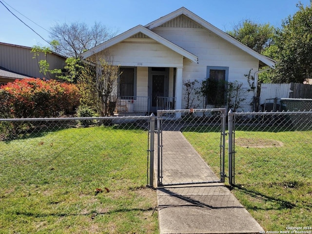 bungalow-style home featuring a fenced front yard, a front yard, and a gate