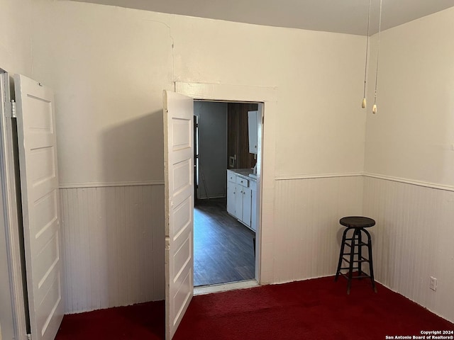 hallway featuring a wainscoted wall and wood finished floors