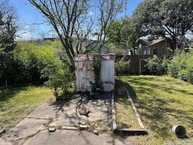 view of yard with an outbuilding, a storage unit, and fence