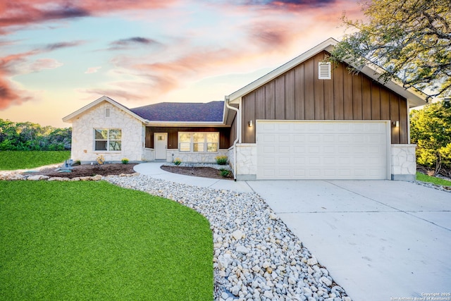 single story home with an attached garage, stone siding, a front lawn, and concrete driveway