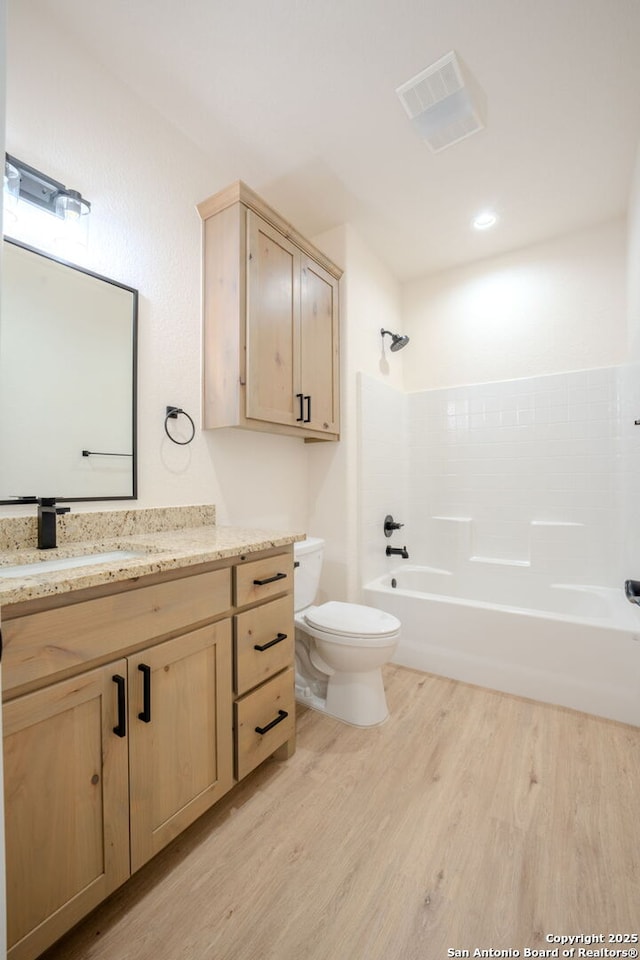 full bath with shower / washtub combination, visible vents, toilet, vanity, and wood finished floors