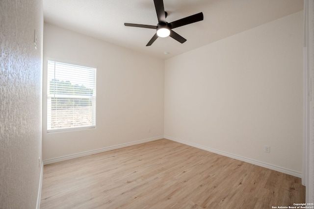 empty room with baseboards, a ceiling fan, and light wood-style floors