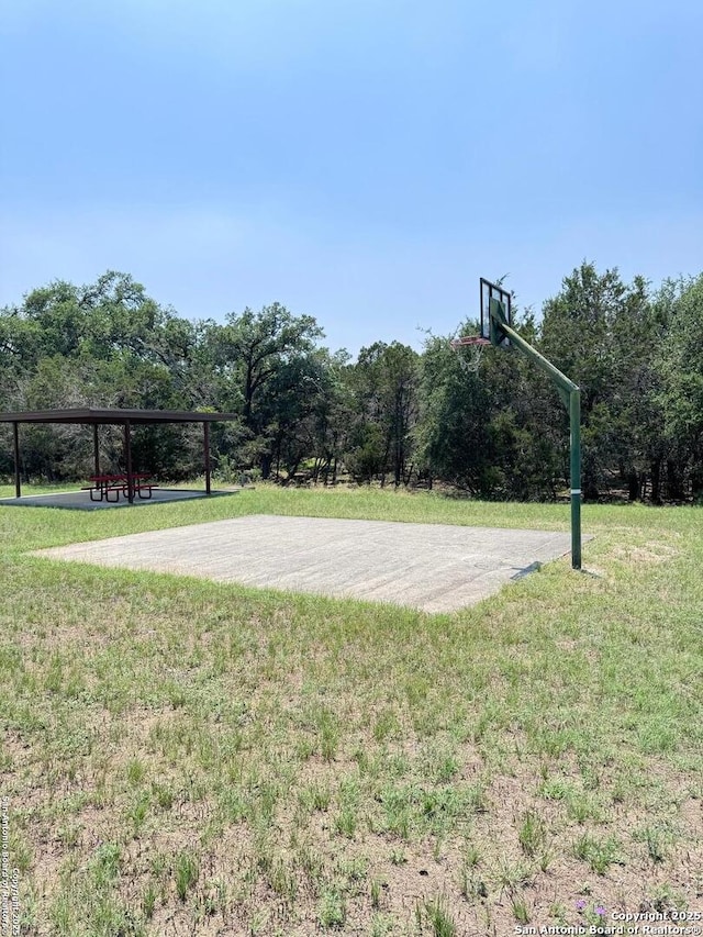 view of basketball court with community basketball court and a lawn