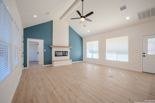 unfurnished living room featuring a large fireplace, beam ceiling, light wood-style flooring, and visible vents