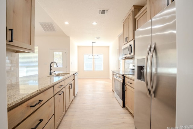 kitchen with decorative light fixtures, visible vents, light brown cabinetry, appliances with stainless steel finishes, and a sink