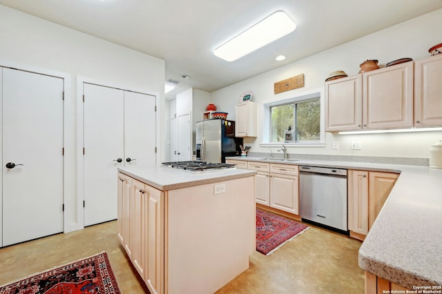 kitchen featuring a kitchen island, appliances with stainless steel finishes, light countertops, and a sink