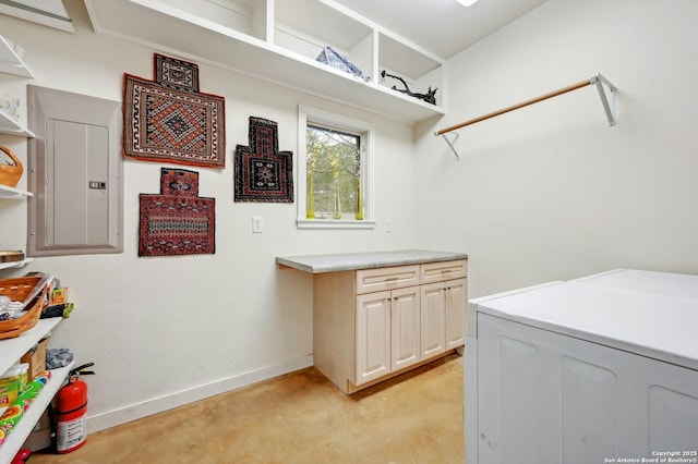 washroom with electric panel, cabinet space, and baseboards