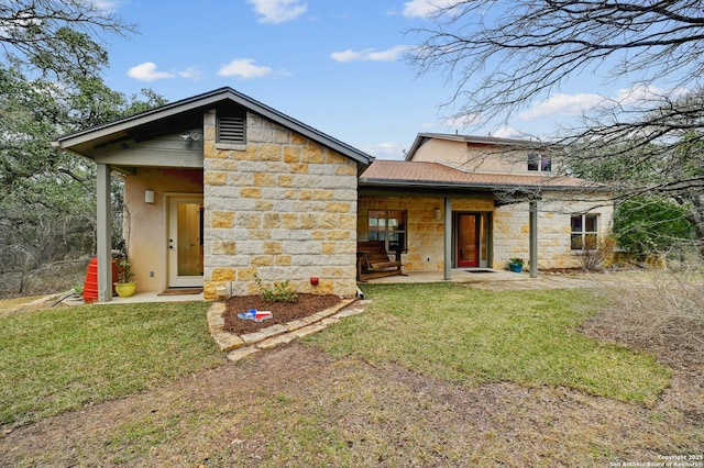 back of property featuring stone siding, a lawn, and stucco siding