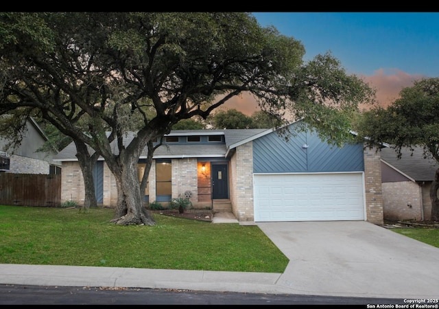 mid-century modern home with driveway, a garage, fence, a front lawn, and brick siding