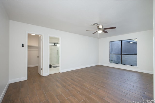 spare room with dark wood-type flooring, visible vents, baseboards, and a ceiling fan