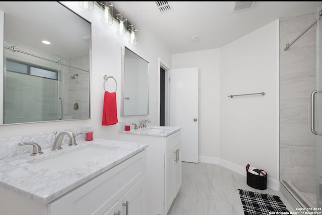 bathroom with marble finish floor, visible vents, a sink, and a shower stall