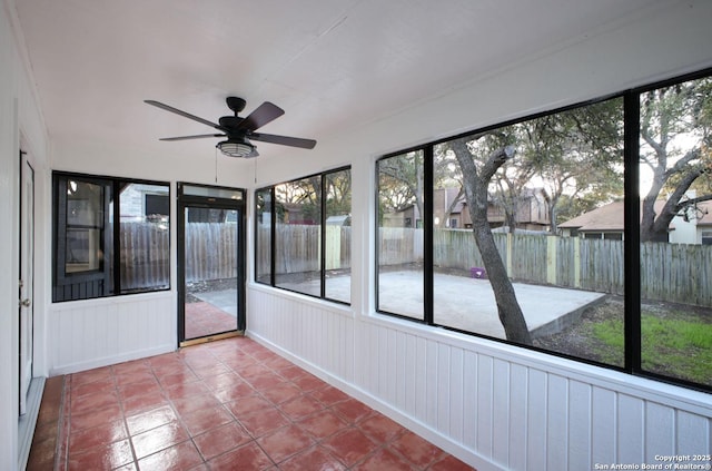 unfurnished sunroom with ceiling fan