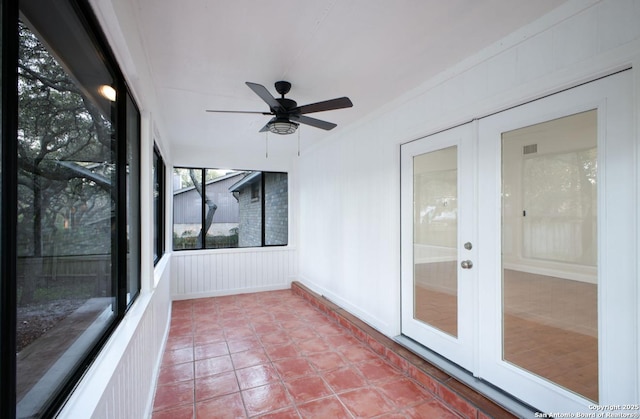 unfurnished sunroom featuring ceiling fan and french doors