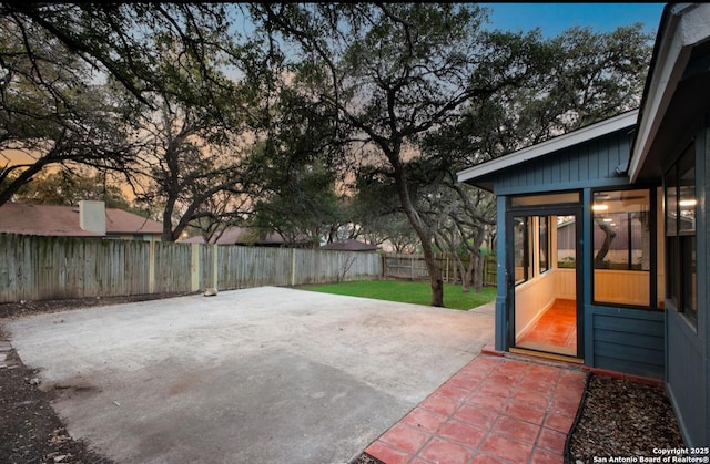 patio terrace at dusk with a fenced backyard