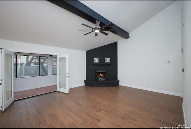 unfurnished living room with a large fireplace, baseboards, beamed ceiling, and wood finished floors