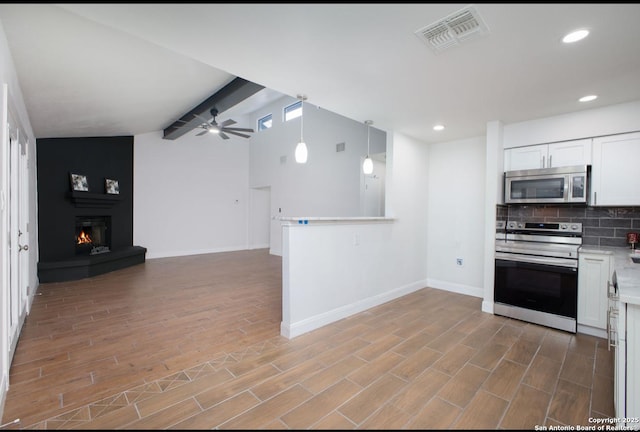 kitchen featuring visible vents, appliances with stainless steel finishes, open floor plan, light countertops, and white cabinetry