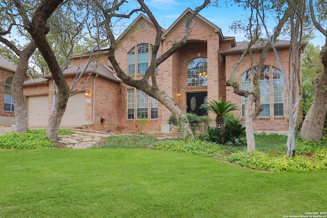 view of front of property with a garage, a front yard, and brick siding