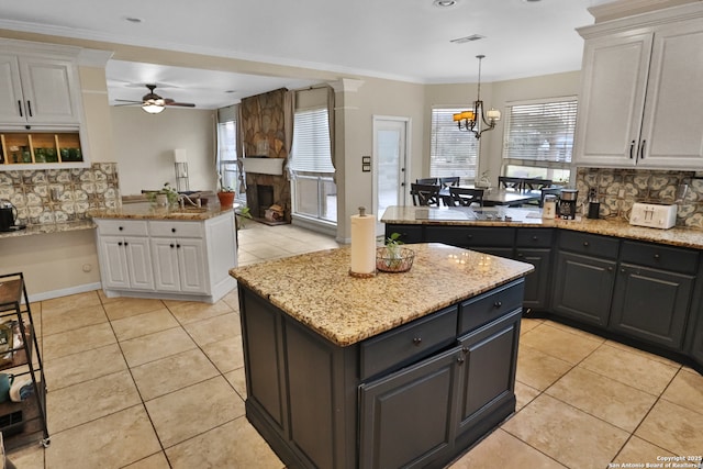 4114 Luckenbach, San Antonio, TX 78251 - kitchen with backsplash, a fireplace, a kitchen island, and white cabinets