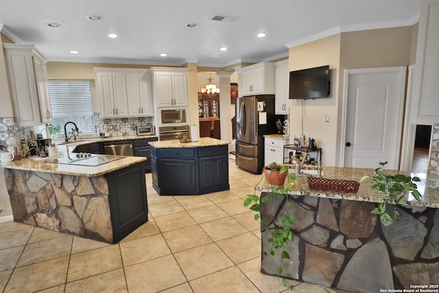 4114 Luckenbach, San Antonio, TX 78251 - kitchen featuring white cabinetry, a kitchen island, appliances with stainless steel finishes, and light stone counters