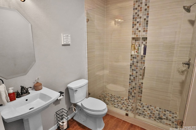 4114 Luckenbach, San Antonio, TX 78251 - bathroom featuring a sink, wood finished floors, toilet, and a shower stall