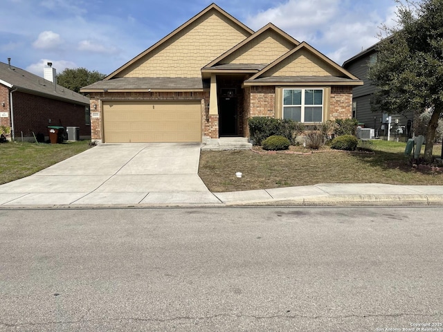 craftsman house featuring driveway, brick siding, an attached garage, and central air condition unit